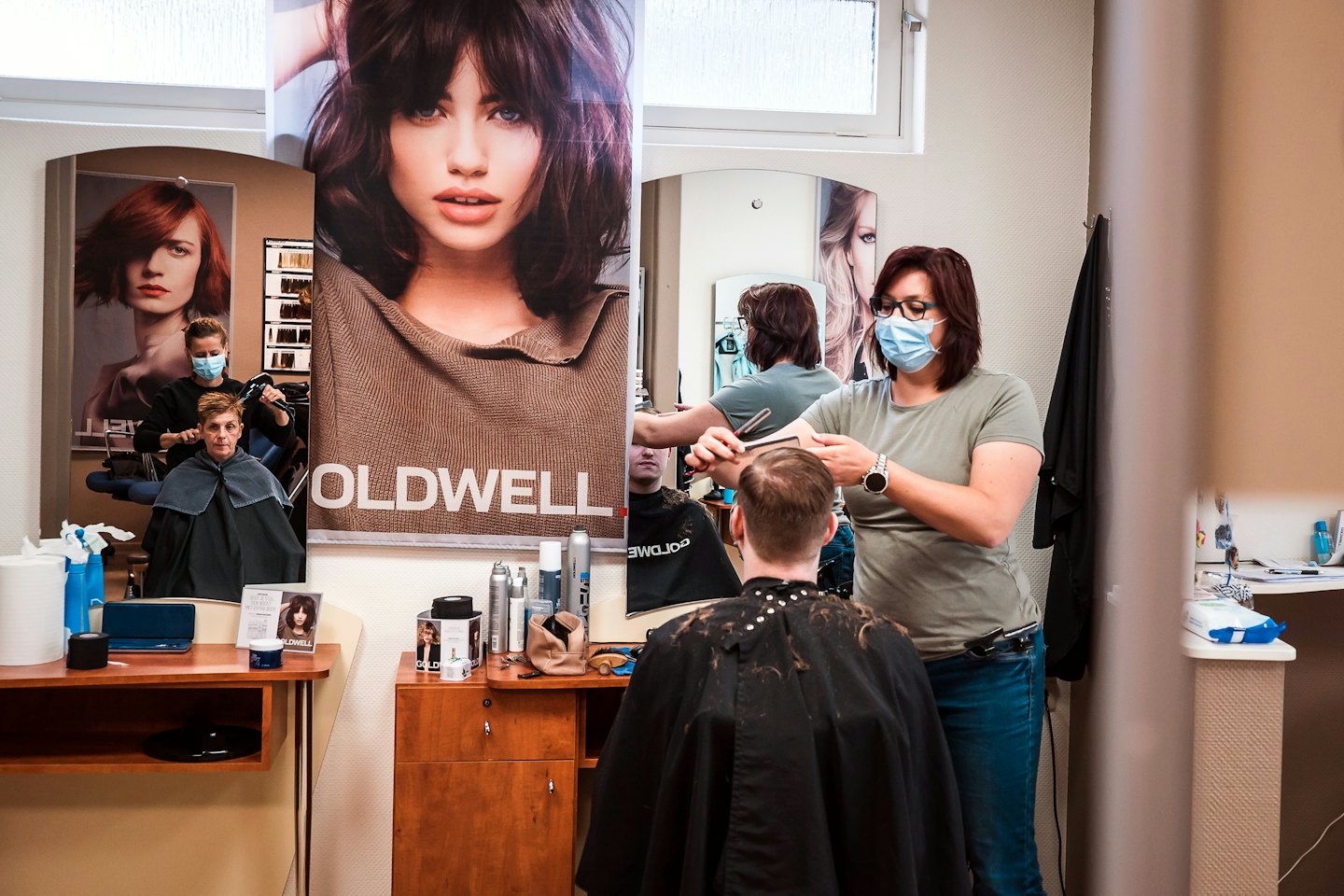 Hairstylist cutting a customer's hair in a professional salon.